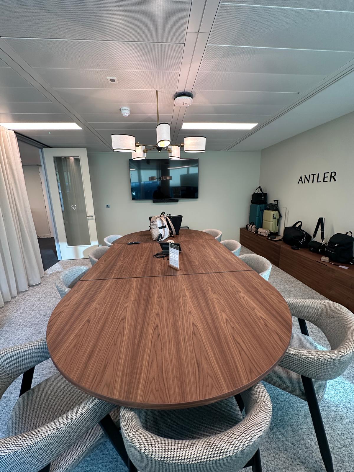 Boardroom with a wall-mounted screen and branded signage
