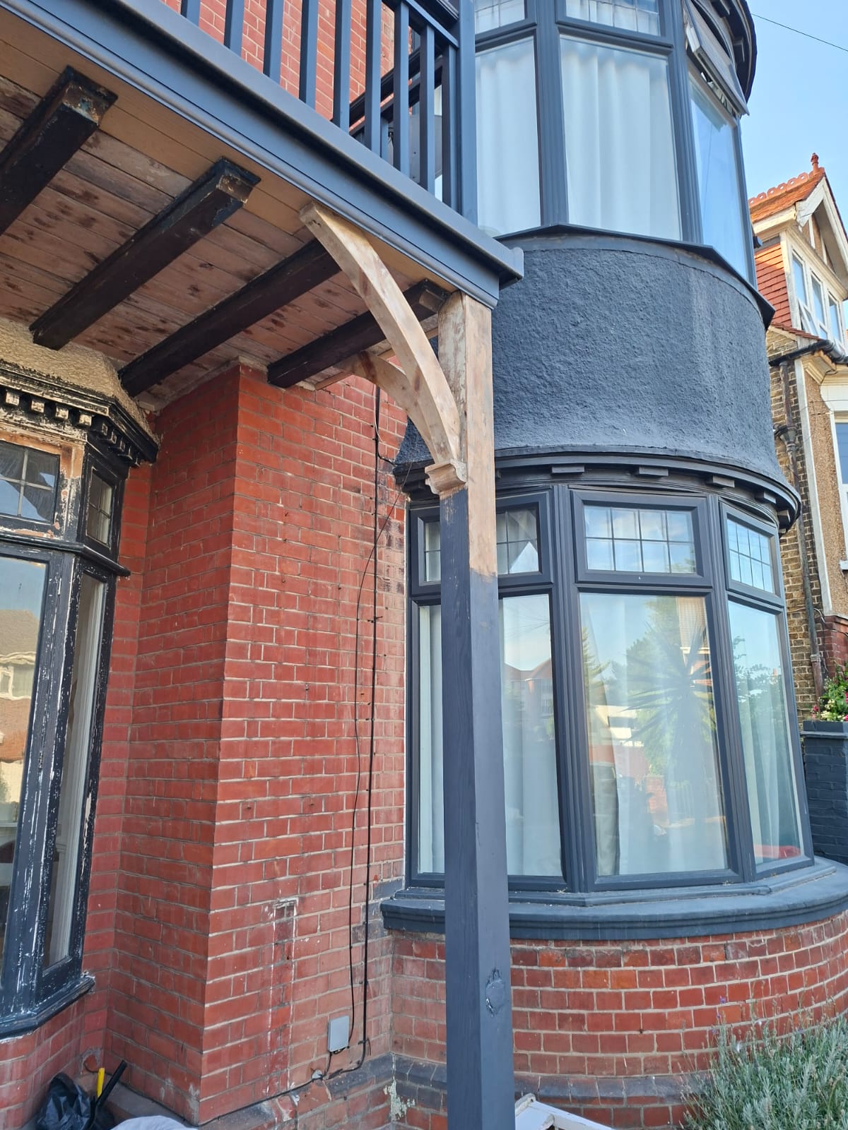 Newly fitted oak corbel bracket supporting the restored balcony and bay window