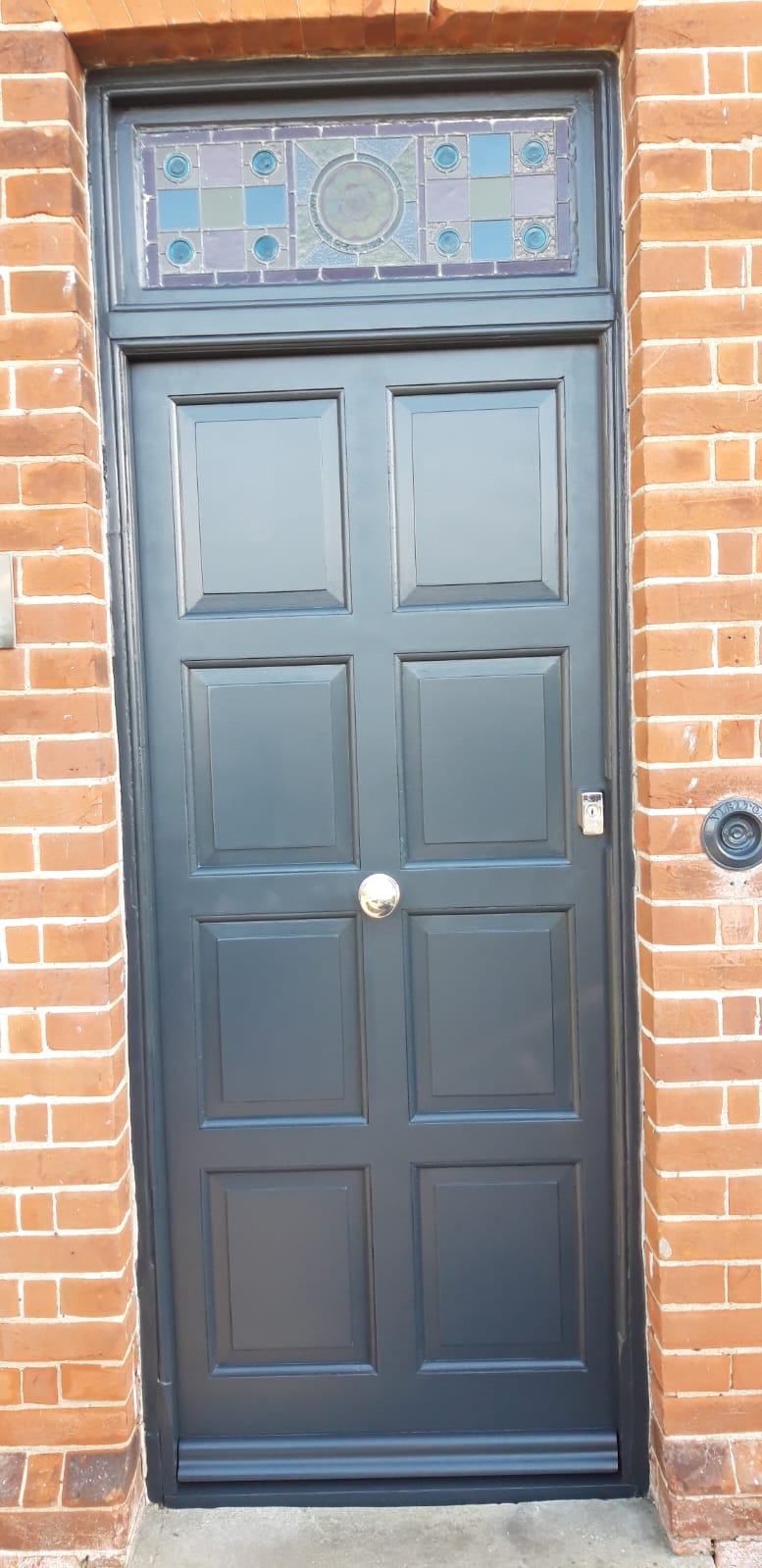 Period panelled front door and stained-glass fanlight repainted in near-black