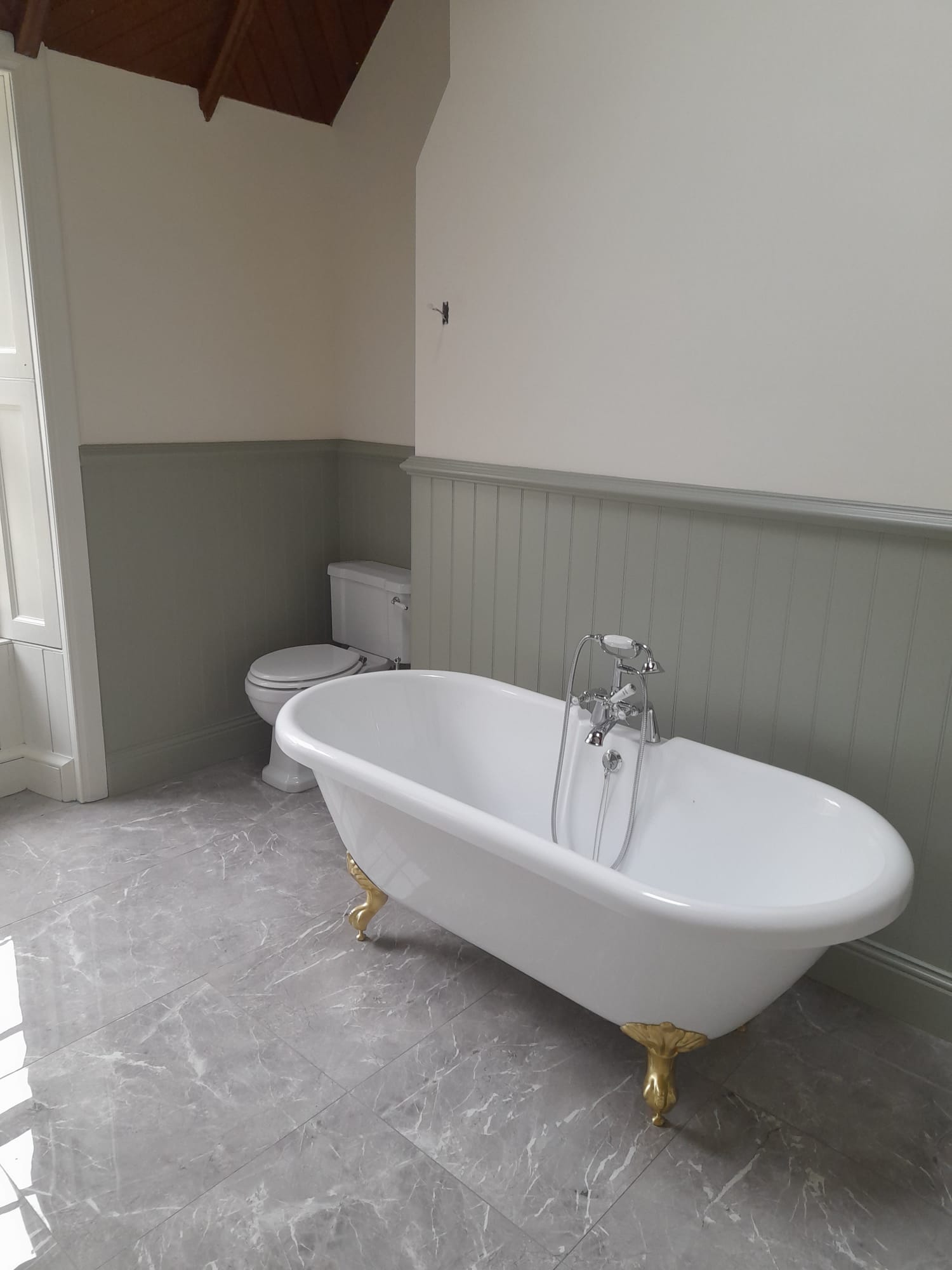 Elegant painted bathroom with a roll-top bath