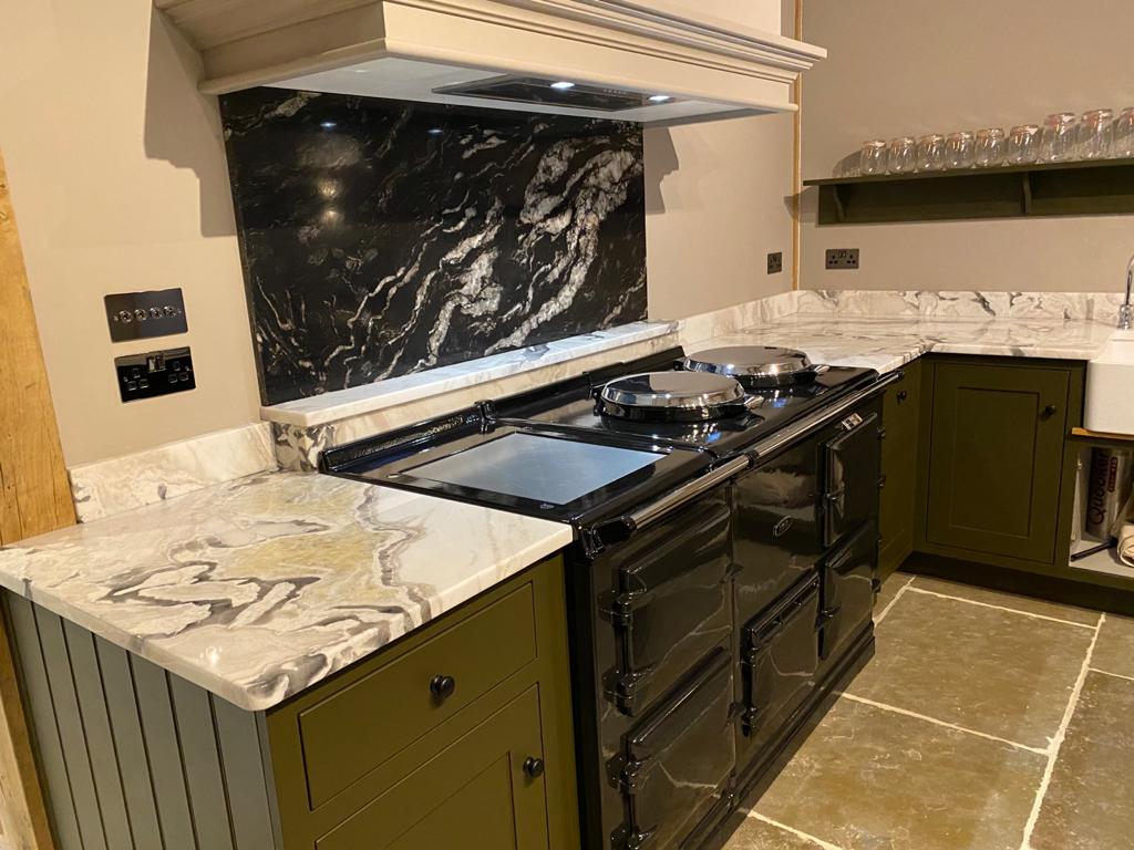 Aga range beneath a black-and-white marble splashback