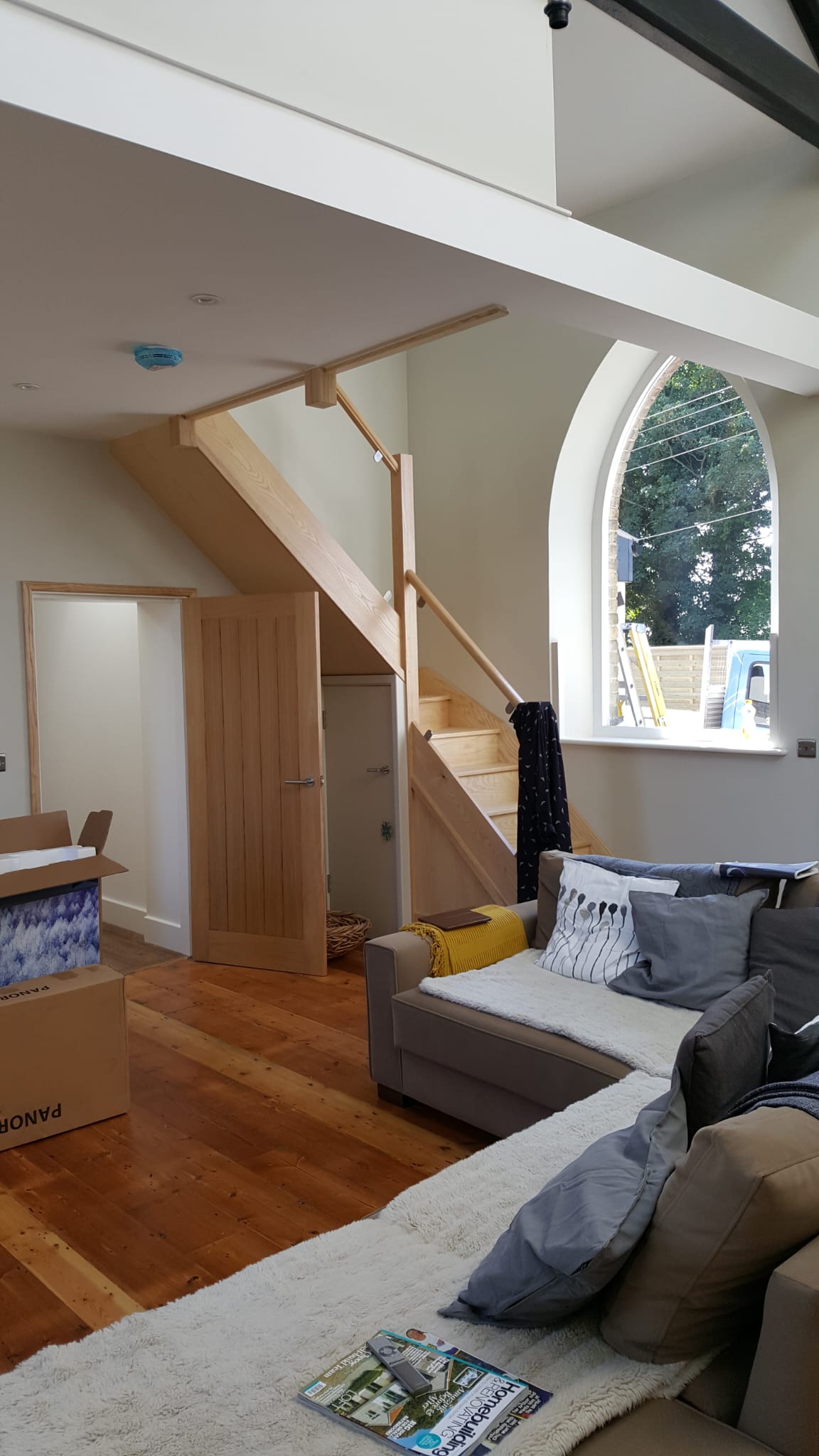 Restored period living room with vaulted ceiling and oak staircase